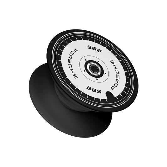 A black pop socket phone grip featuring a top design mimicking a black and white Porsche BBS center lock wheel nut - automotive phone accessory by Stick-On Limited.