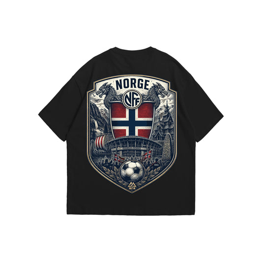 A black oversized t-shirt shown from the front and back. The front features a small Norway crest with the red text 'Hela, hela, Norgel!'. The back displays a large, intricate heritage graphic with 'NORGE', an NFF logo, traditional dragon heads, a Viking ship, Ullevaal Stadion, a stave church, a runestone, and a football.